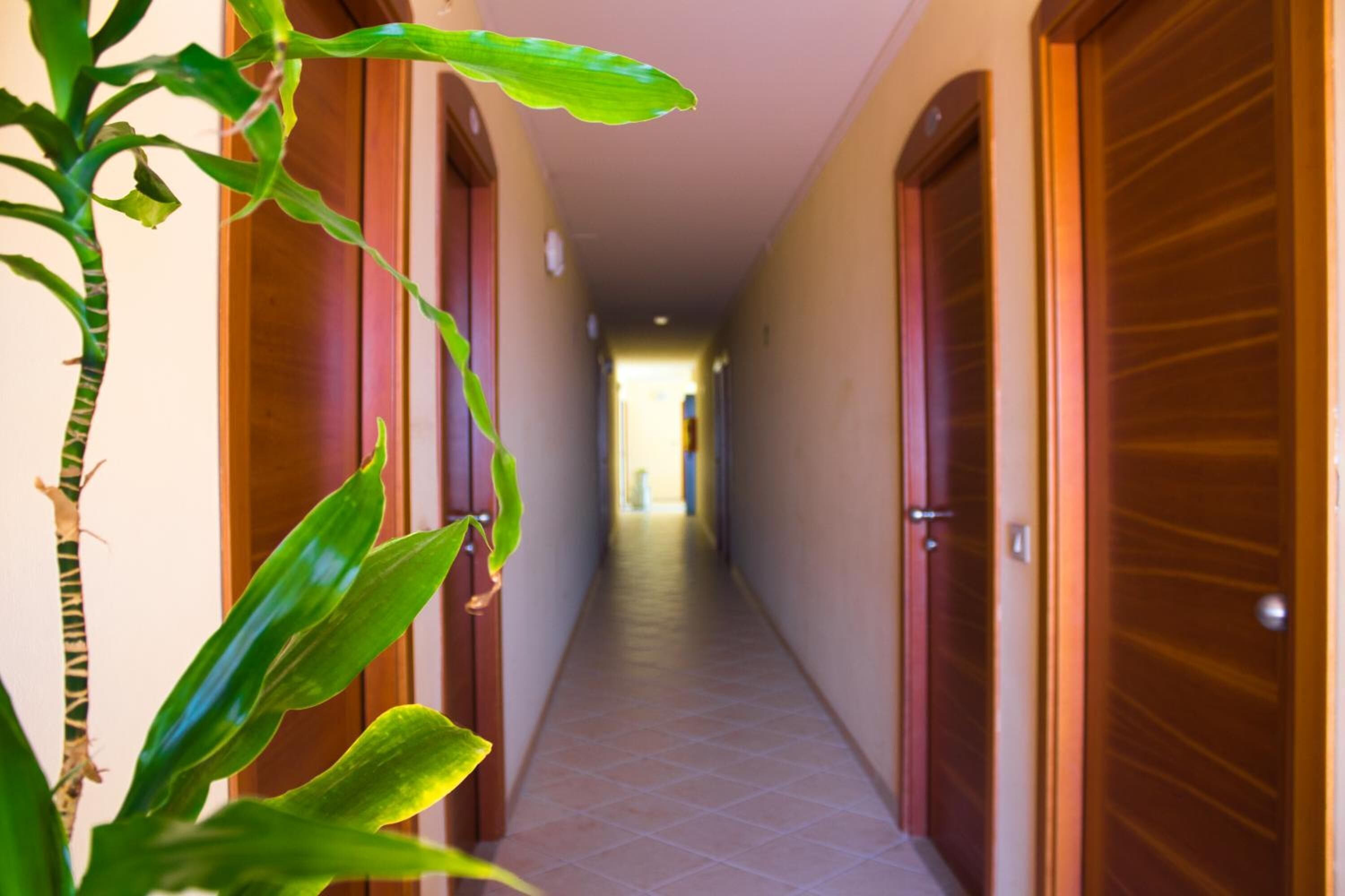 A hallway with wooden doors and a tiled floor.