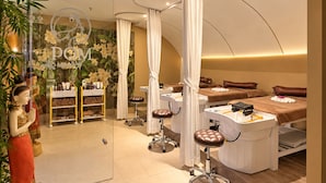 Een spa-ruimte met een massagetafel, een wastafel en een plank met toiletartikelen.