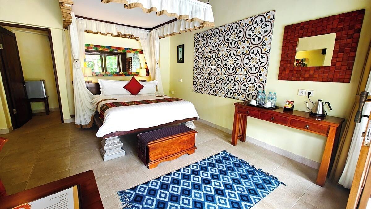 A bedroom with a bed, bedside table, and a wall with a patterned tile design.