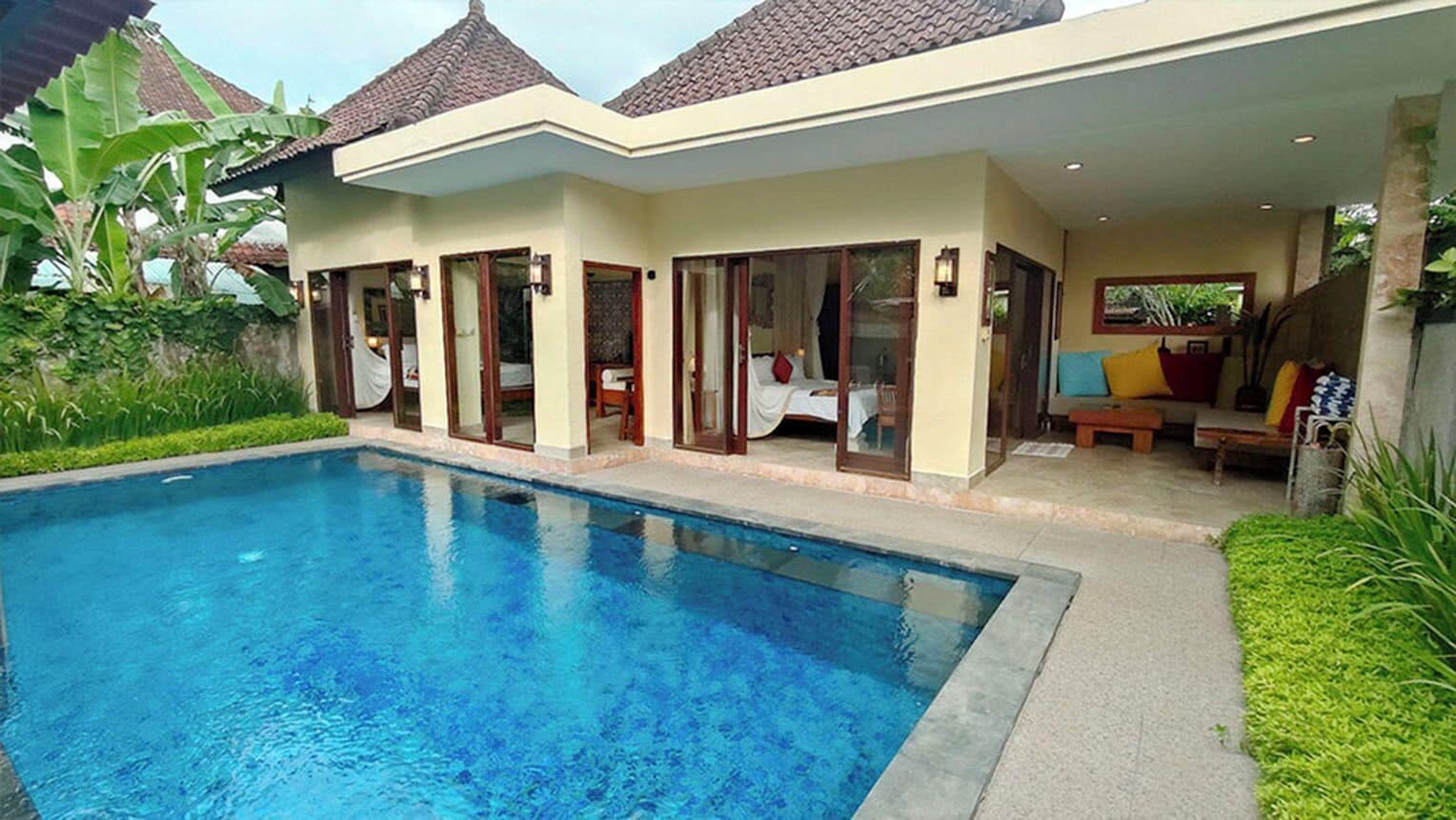 A modern house with a swimming pool, large glass doors, and a patio area with outdoor furniture.