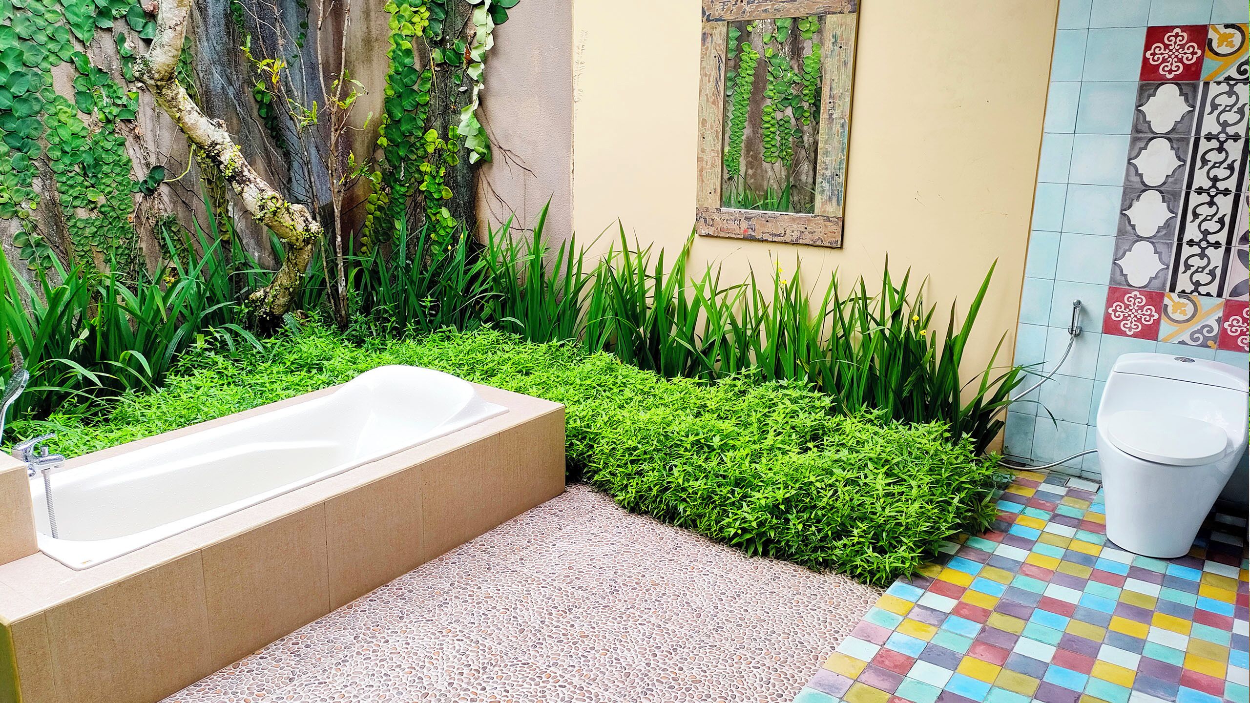 A bathroom with a bathtub, a toilet, and a tiled floor.