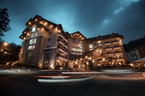 A multi-story hotel with a stone facade, balconies, and a starry night sky. - Azalea Hotels & Residences Baguio (Baguio)