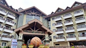 A multi-story hotel with balconies, a central entrance with a decorative fountain, and potted plants. - Azalea Hotels & Residences Baguio (Baguio)