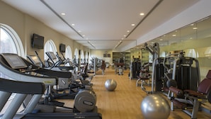 Un gimnasio con cintas de correr, elípticas y pesas sueltas.