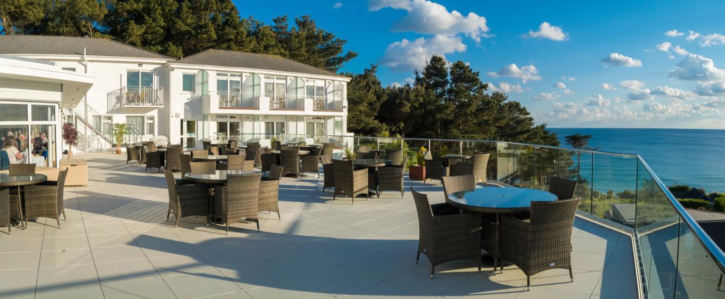Un hotel frente al mar con terraza exterior y vistas al océano.