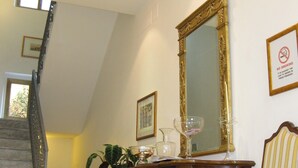 A staircase with a marble finish, a wooden dresser with a mirror, a chair with striped upholstery, and a 'No Smoking' sign on the wall. - La Rotella nel Sacco (Rome)