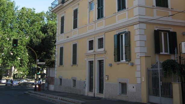 A multi-story building with a yellow facade, white trim, and green shutters. - La Rotella nel Sacco (Rome)