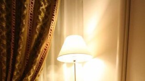 A small, round glass table with two chairs, a lamp, and a small box on the table. - La Rotella nel Sacco (Rome)