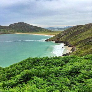 A coastal landscape with a beach, green hills, and a clear sky. - Kee's Hotel  (Stranorlar)