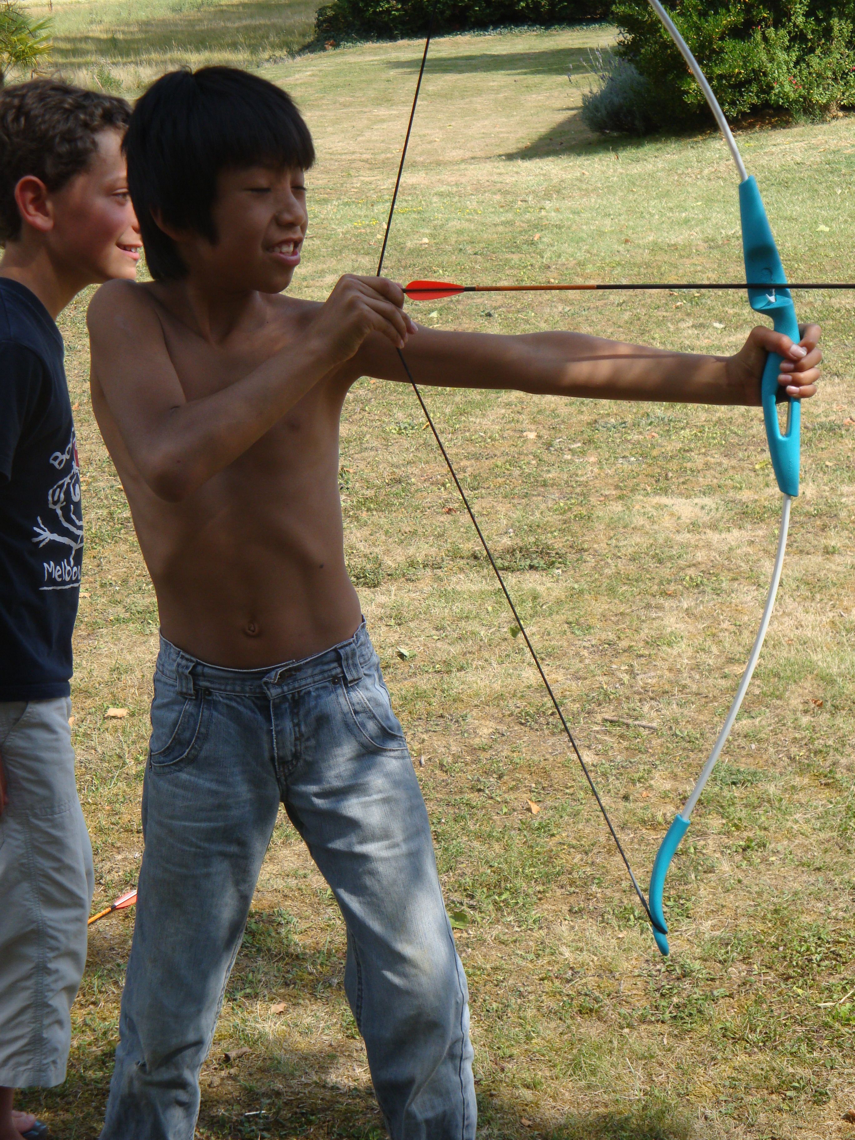 A person holding a bow and arrow outdoors.