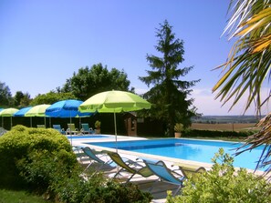 Relax by the serene pool surrounded by lush greenery and comfortable lounge chairs.