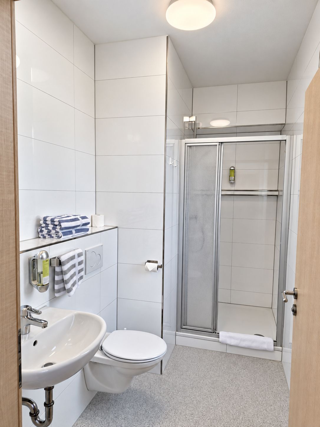 Une salle de bain moderne équipée d’une douche, de toilettes et d’un lavabo.
