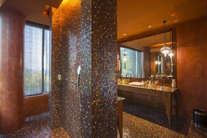 Un baño moderno con pared de mosaicos, un espejo grande y un tocador doble.