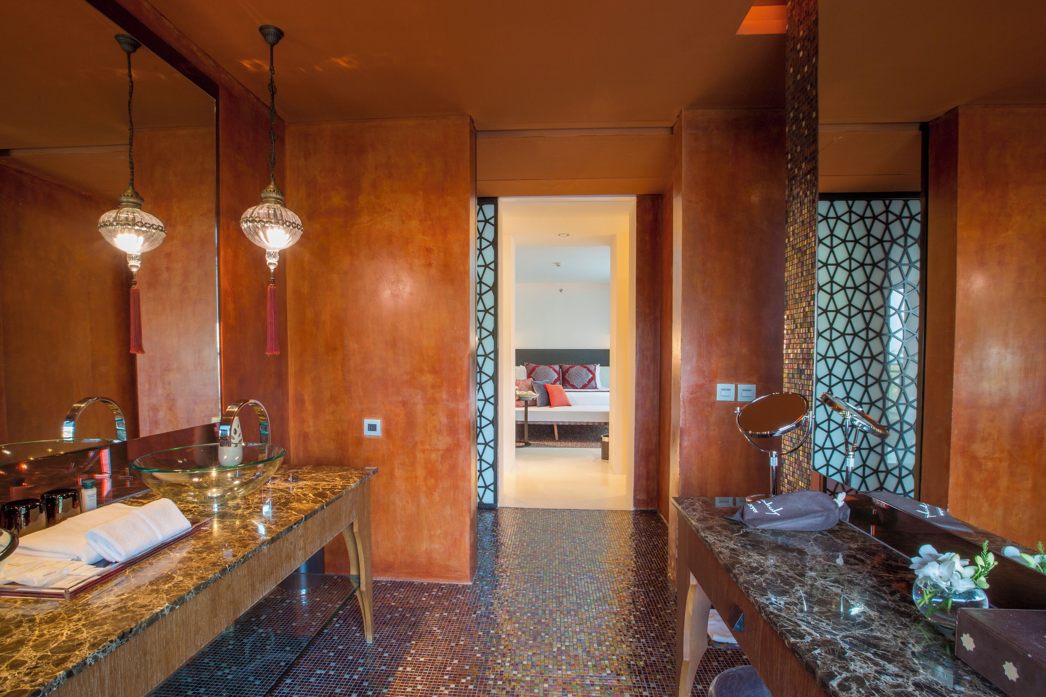 A modern bathroom with a large mirror, two sinks, and a vanity.