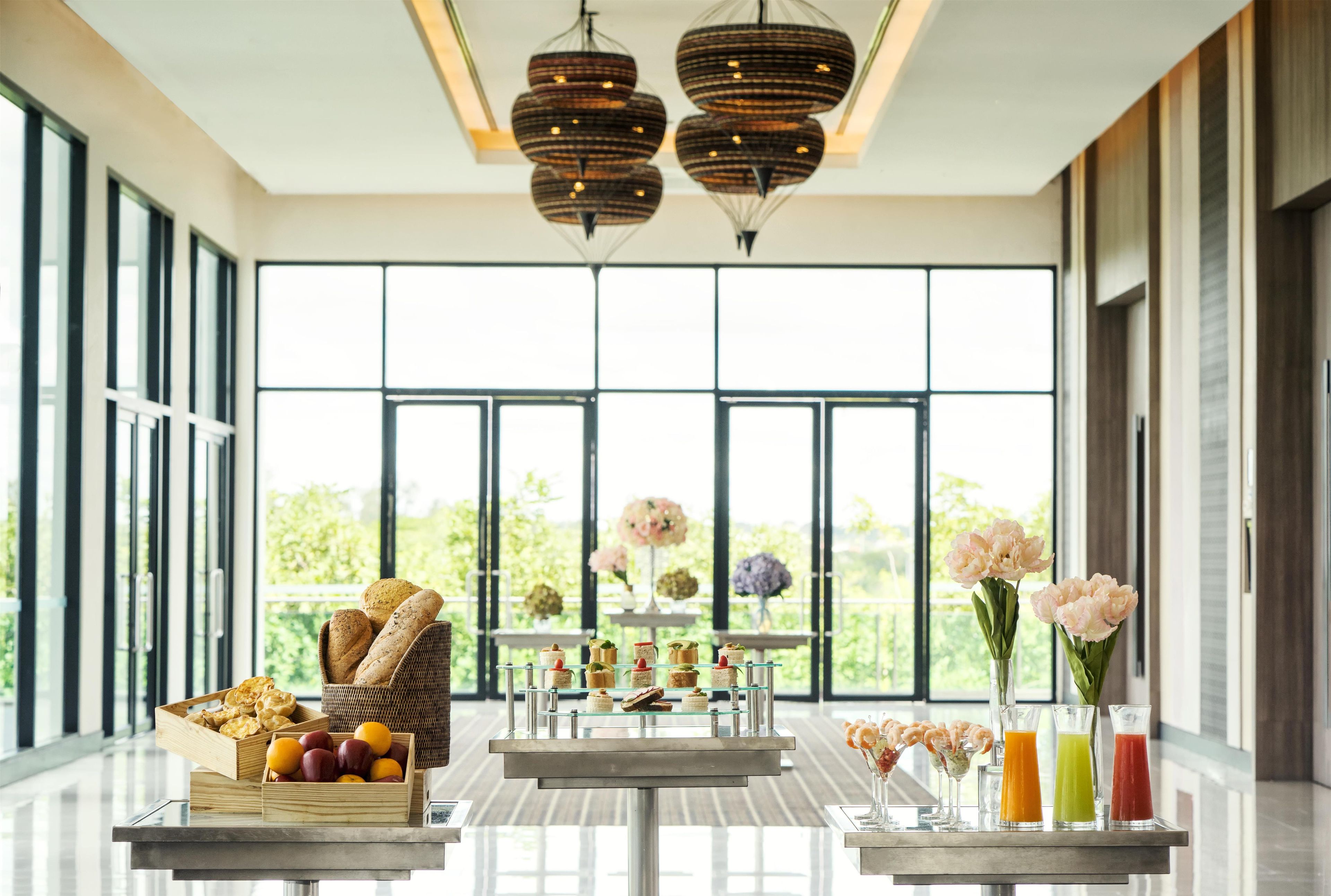 A modern interior with large windows, a dining area with a buffet, and a bar with drinks.
