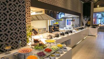 A buffet with various food options, including salads, meats, and cheeses, arranged on a long counter with decorative wall panels.