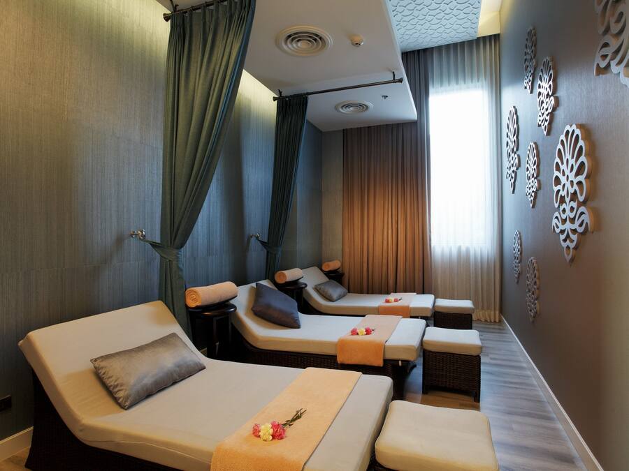 A spa room with massage tables, a curtain, and decorative wall art.