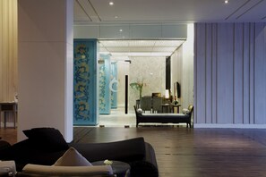 Un moderno vestíbulo de hotel con zona de estar, mostrador de recepción y una pared decorativa.