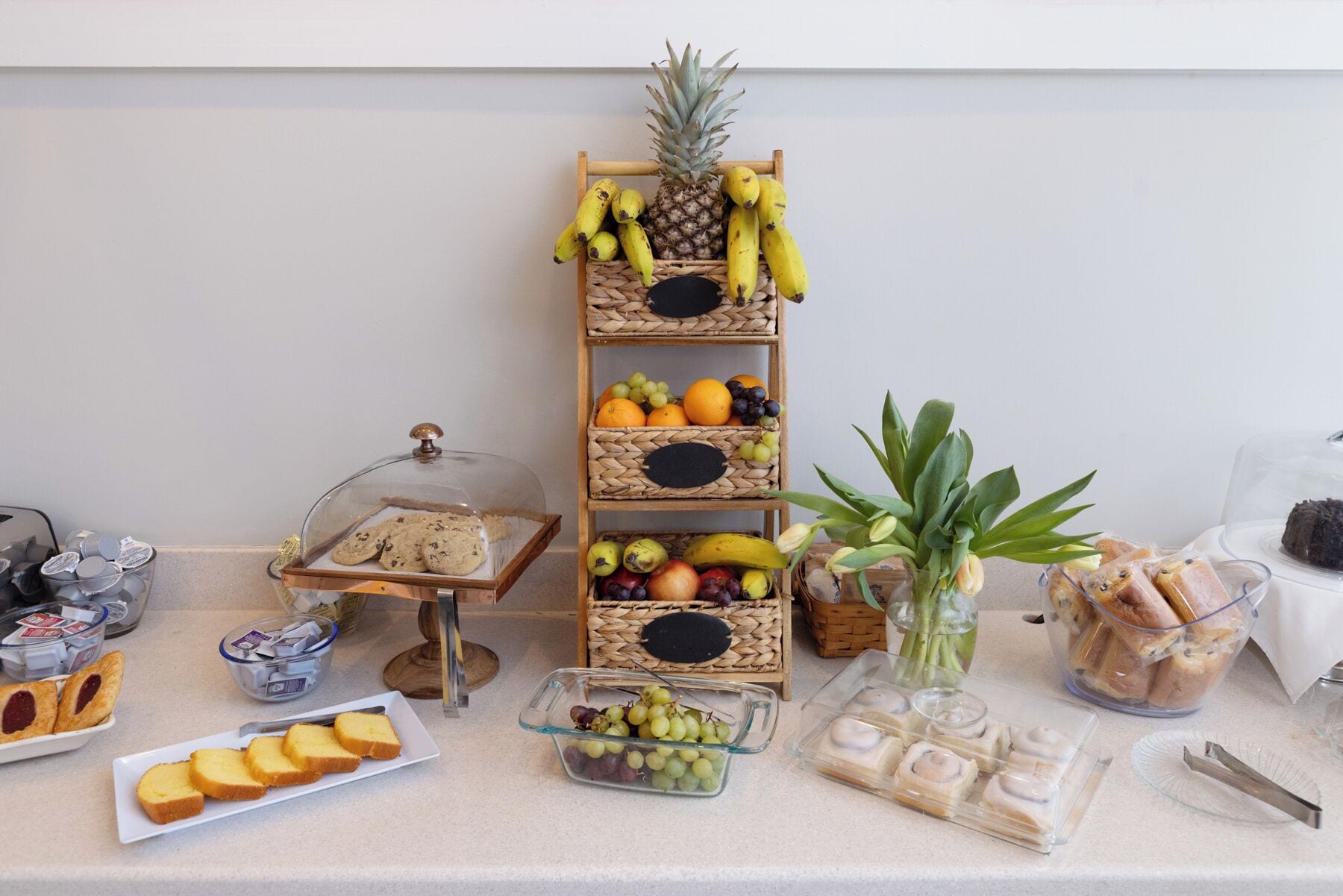 A buffet table with various food items and a fruit display.