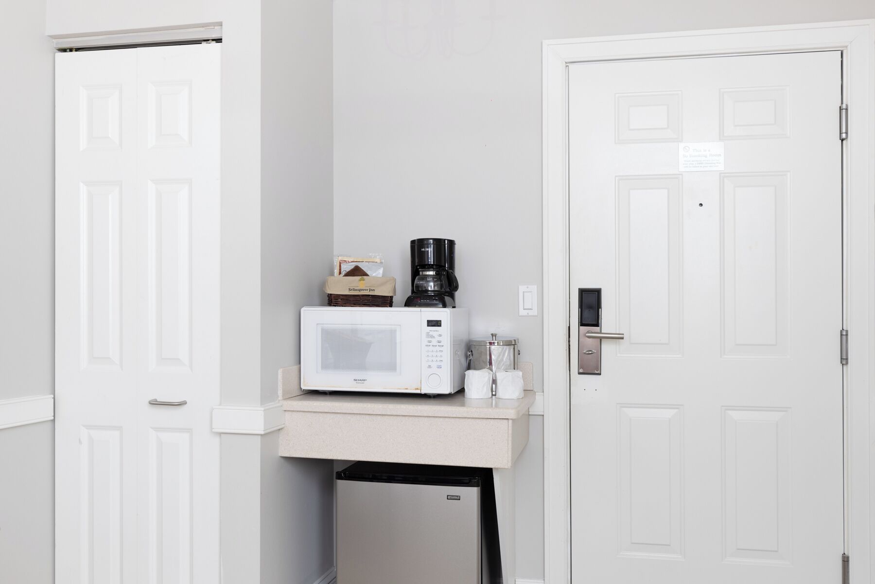 A compact kitchenette with a microwave, coffee maker, and a small refrigerator.