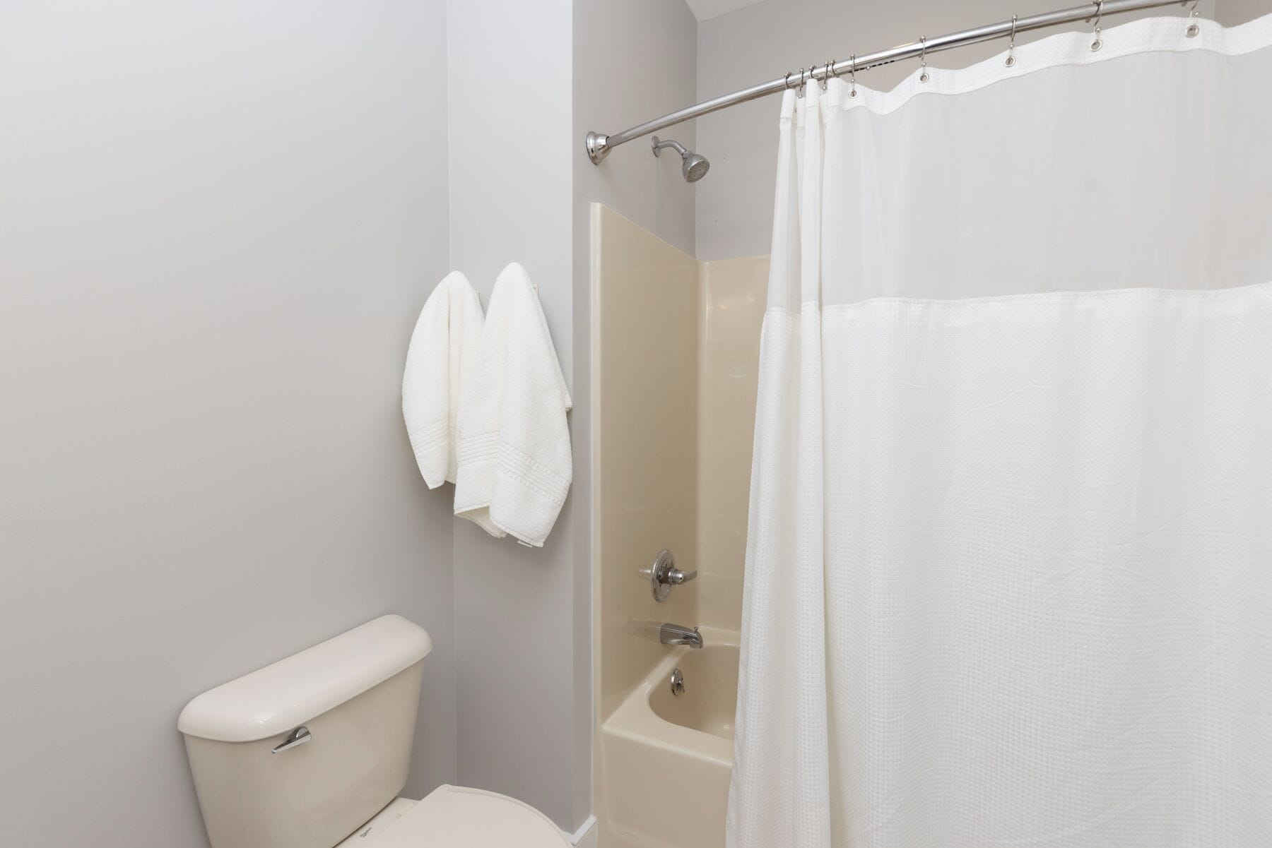 A bathroom with a toilet, a bathtub, and a shower curtain.