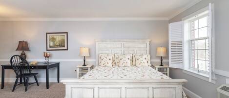 A bedroom with a bed, a desk, a chair, and a bench.