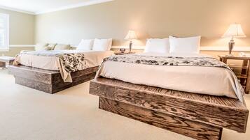 A bedroom with two beds, each with a wooden platform base, and bedside lamps.