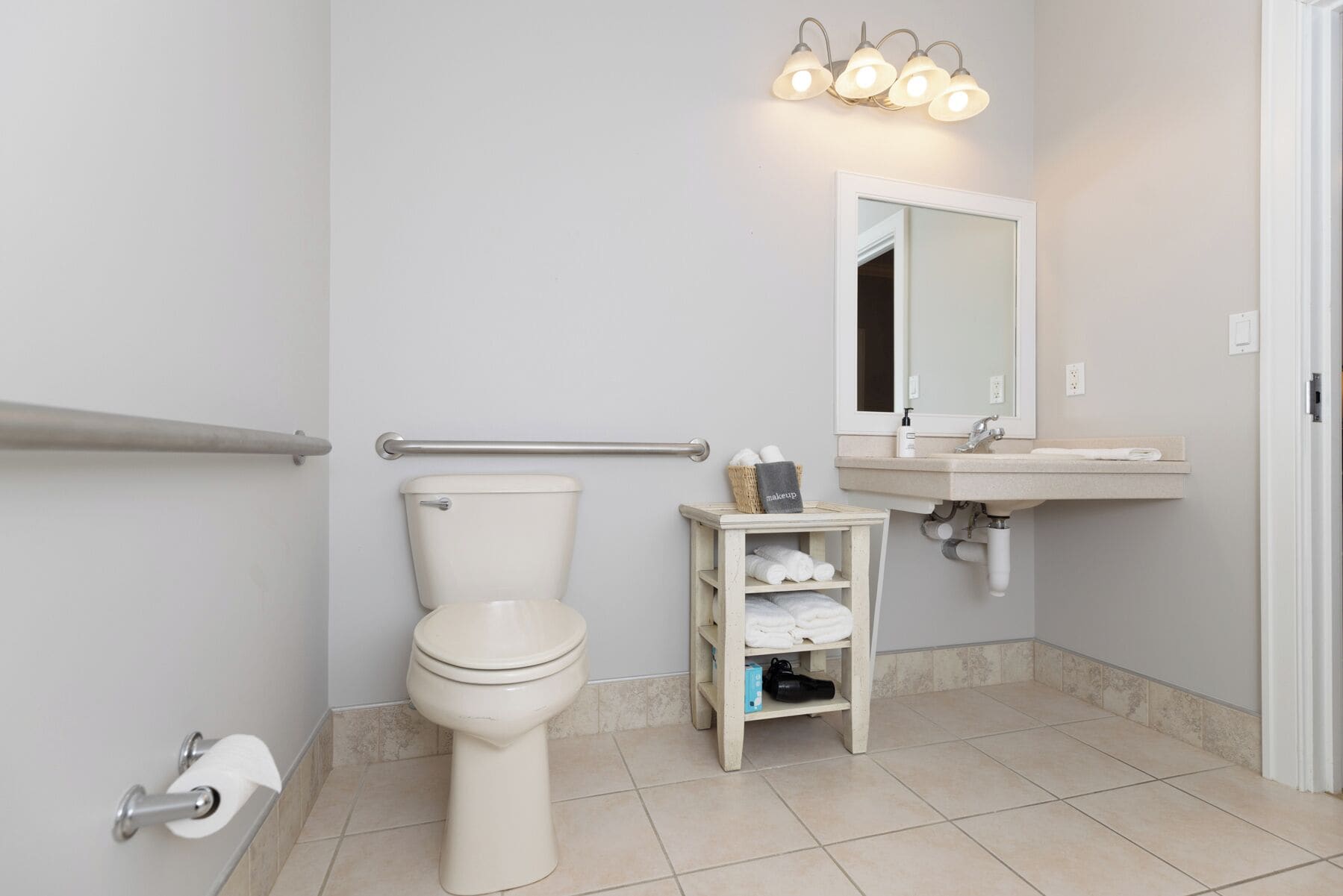 A bathroom with a toilet, a sink, a mirror, and a towel rack.