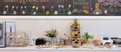 Ein Frühstücksbuffet in der Selinsgrove Inn mit einer Kreidetafel, verschiedenen Speisen und einer Obstauslage.