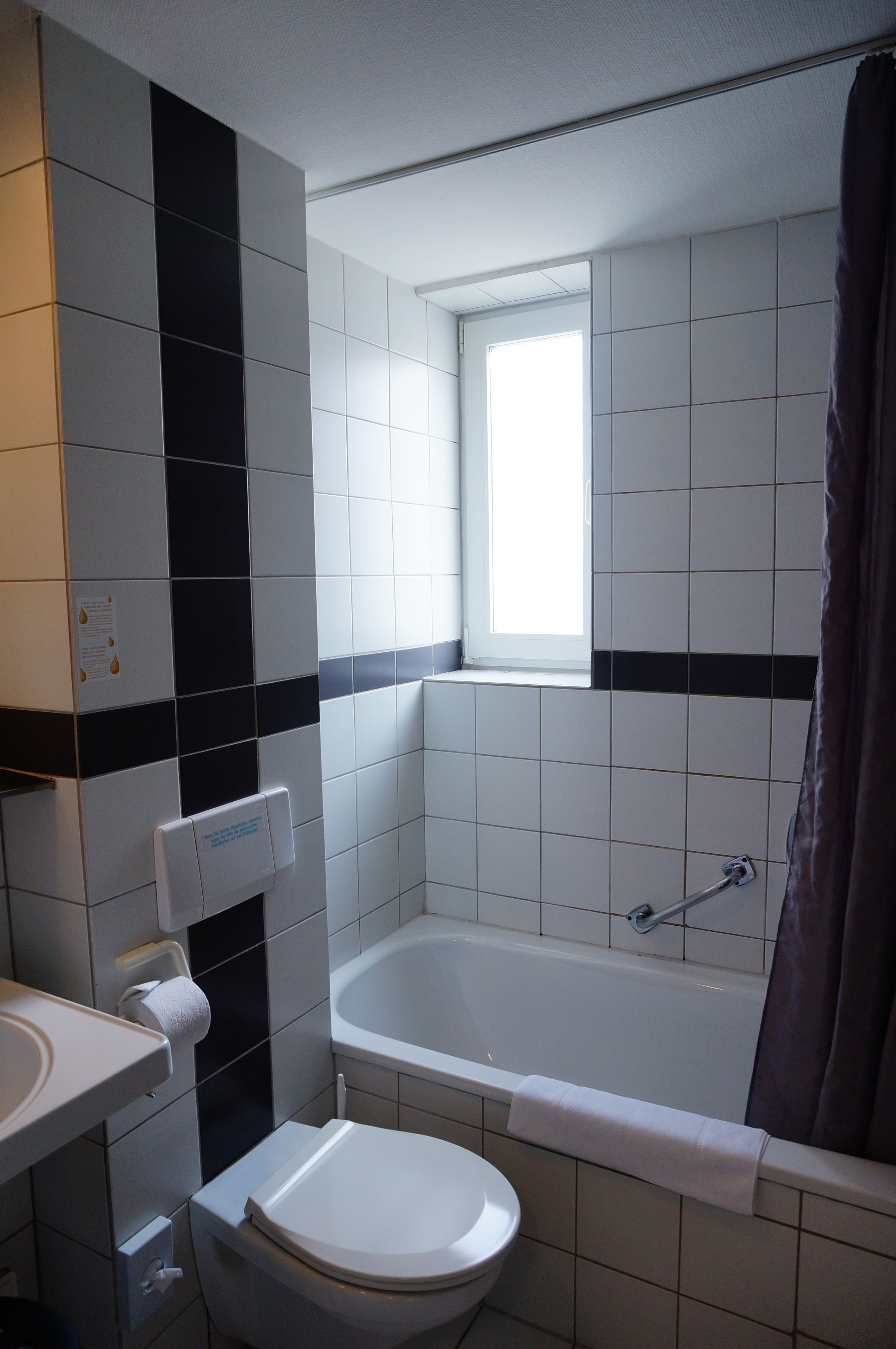 A bathroom with a toilet, sink, and bathtub.