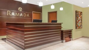 Una mesa de recepción de diseño moderno, con un logotipo sobre el nombre 'RAMADA'.