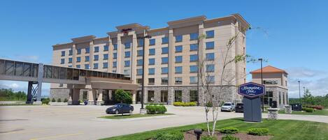 A Hampton Inn hotel with a modern design, a covered walkway, and a parking area.