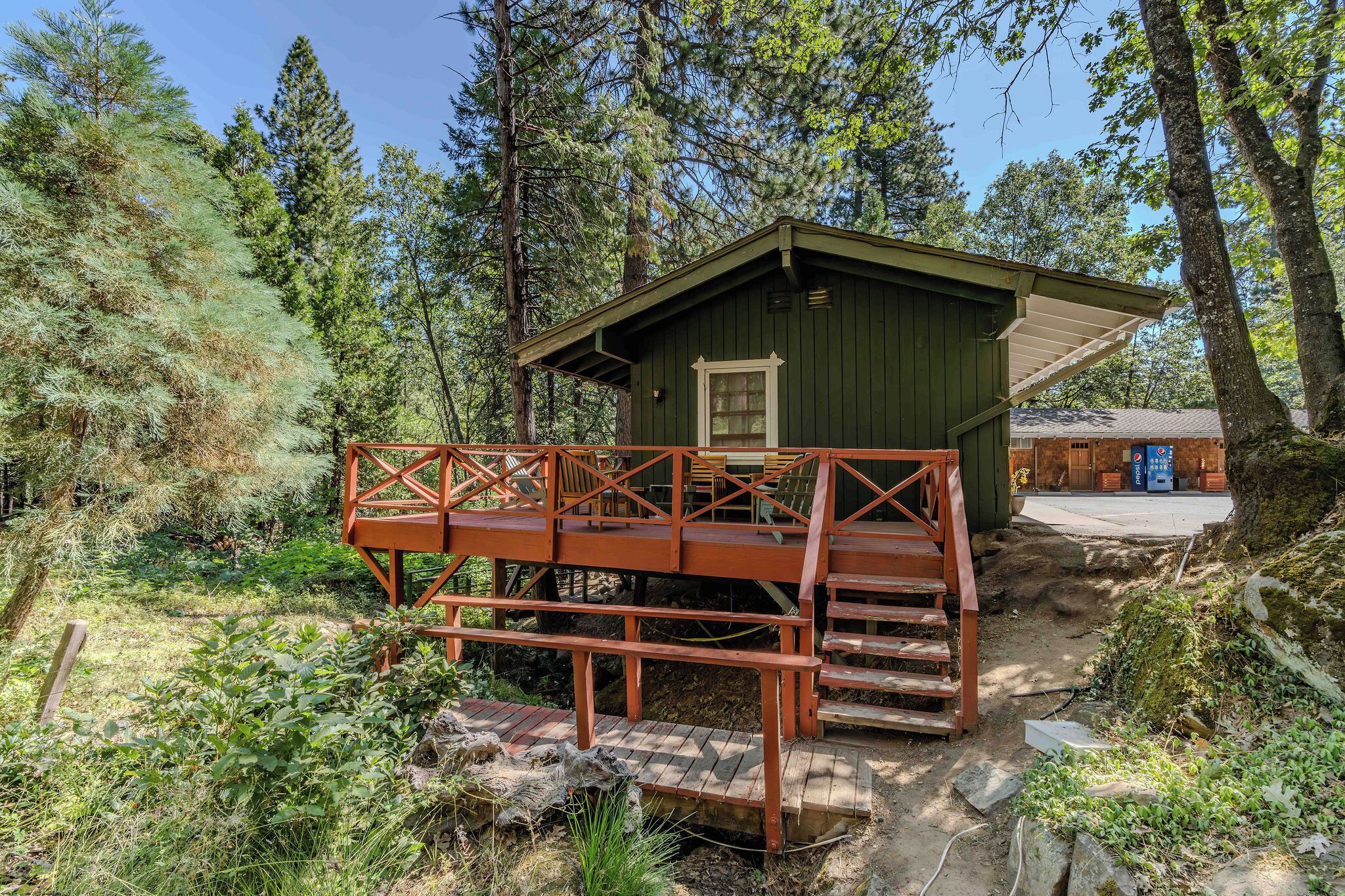 A rustic cabin with a wooden deck and a small porch.