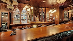 Eine Bar mit Holzvertäfelung, einer großen Skulptur eines Stiers und mehreren Hängeleuchten.