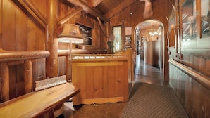 Ein Holzinterieur mit einer Bar, Holzbänken und einem an der Wand befestigten Hirschkopf.
