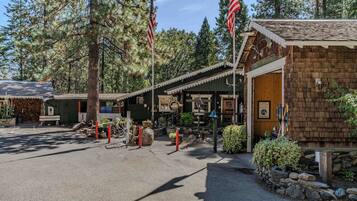 A rustic wooden building with a sign reading "The Attack Co." and American flags.