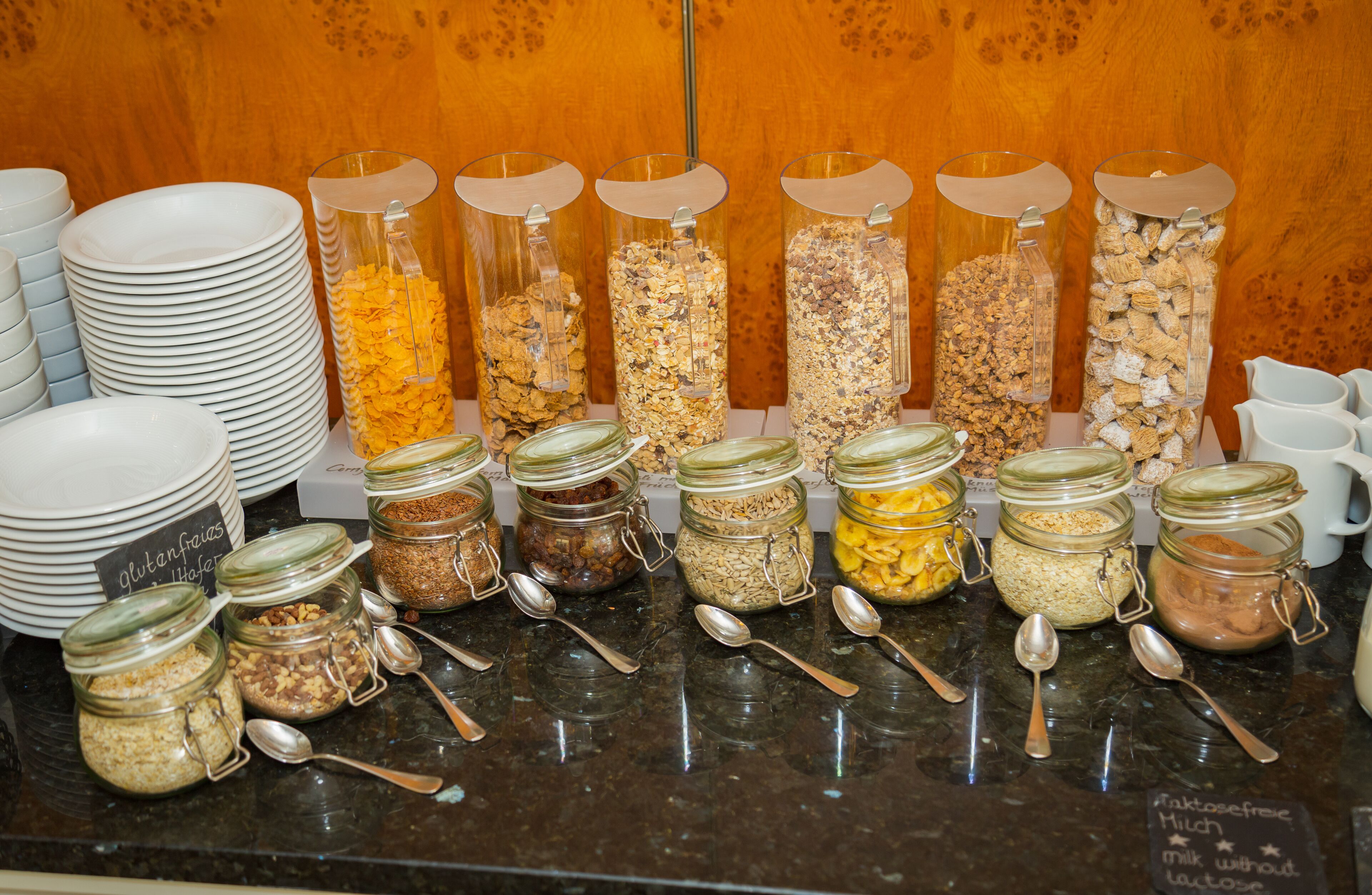 A breakfast buffet with various food options in jars and plates.