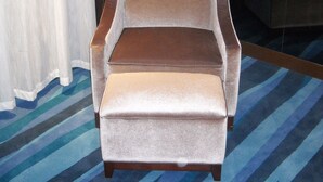 A single brown armchair with a footrest in a hotel room with striped carpet and curtains. - Metropolo Shijiazhuang Yuhua (Shijiazhuang)