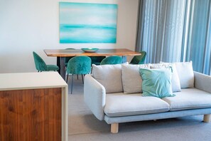Una sala de estar moderna con un sofá, una mesa de comedor y sillas.