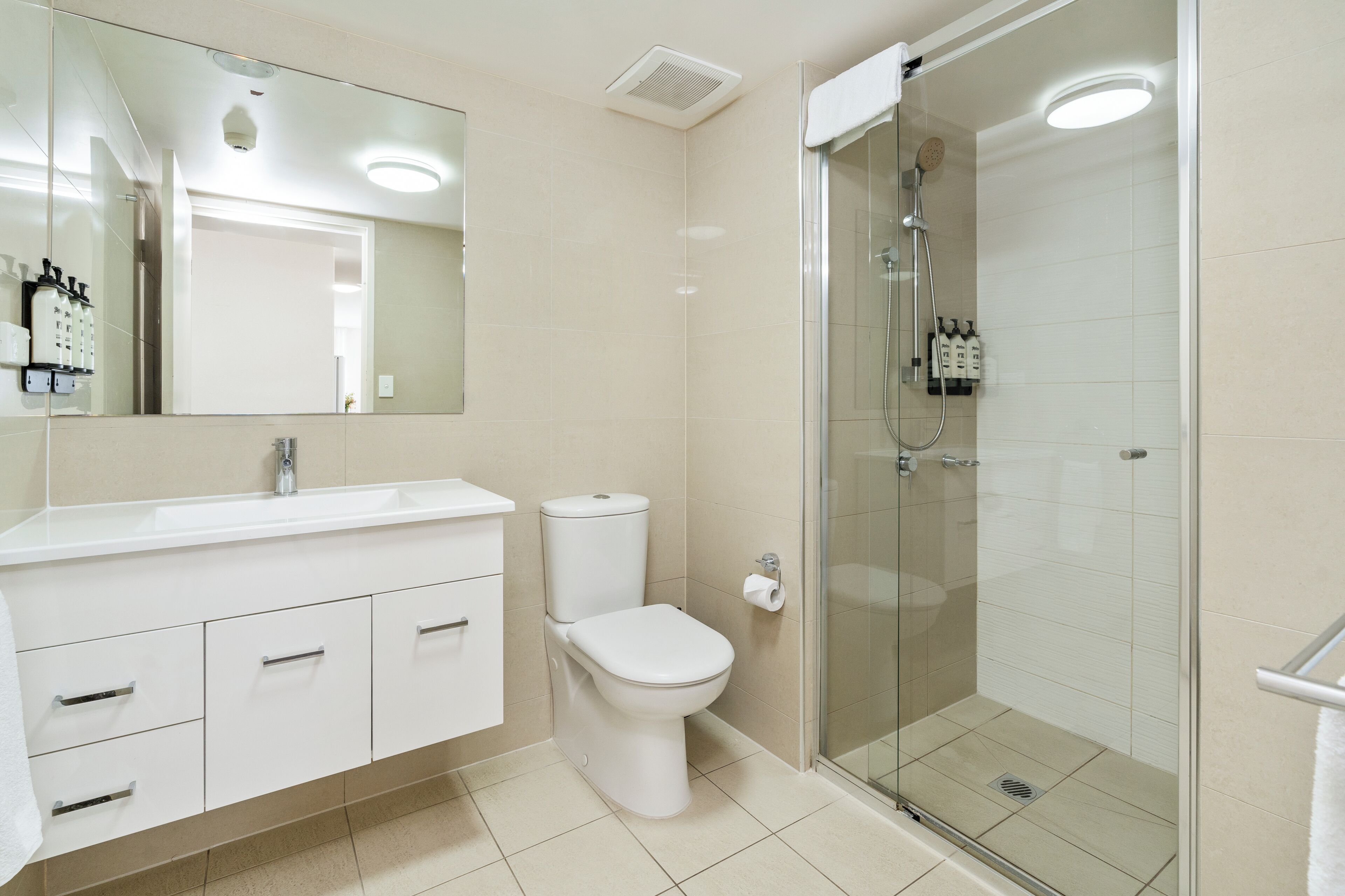 Een moderne badkamer met toilet, wastafel en douchecabine.
