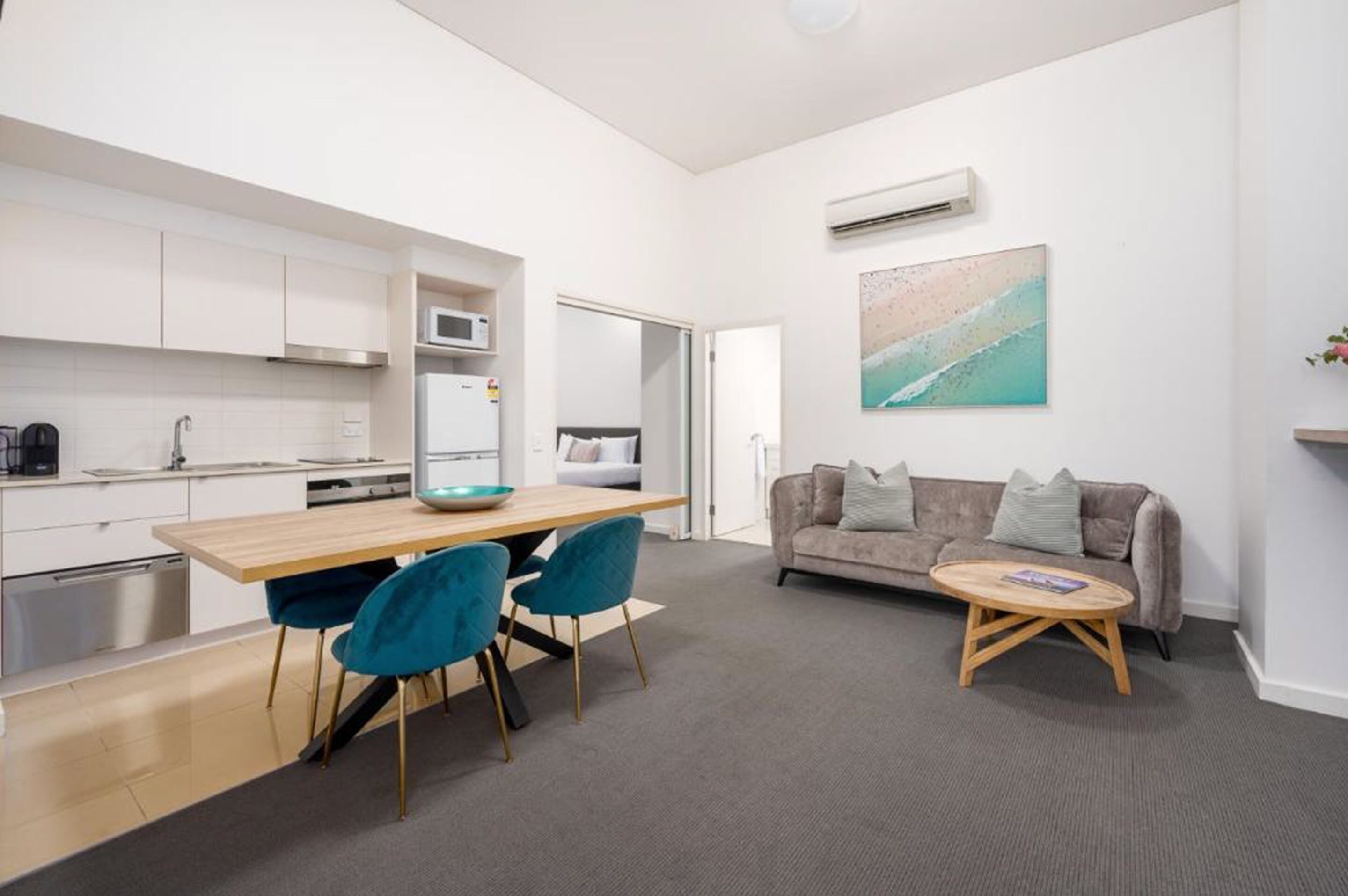 A modern apartment with a kitchen, dining area, and living room.