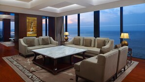 A spacious living room with a large sofa set, a coffee table, and a view of the ocean. - Sheraton Yantai Golden Beach Resort (Yantai)