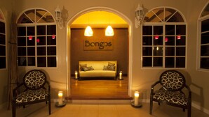 Una habitación con un sofá, dos sillones y una pared con la palabra "Bongos".