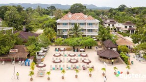 Un resort con varias edificaciones, zonas de estar al aire libre y abundante vegetación.
