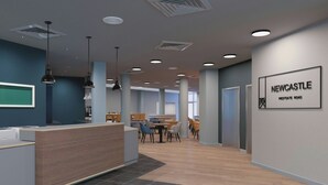 A modern reception area with a wooden reception desk, multiple seating areas, and a sign indicating 'NEWCASTLE WESTGATE ROAD'. - Four Points Flex by Sheraton Newcastle (Newcastle-upon-Tyne)