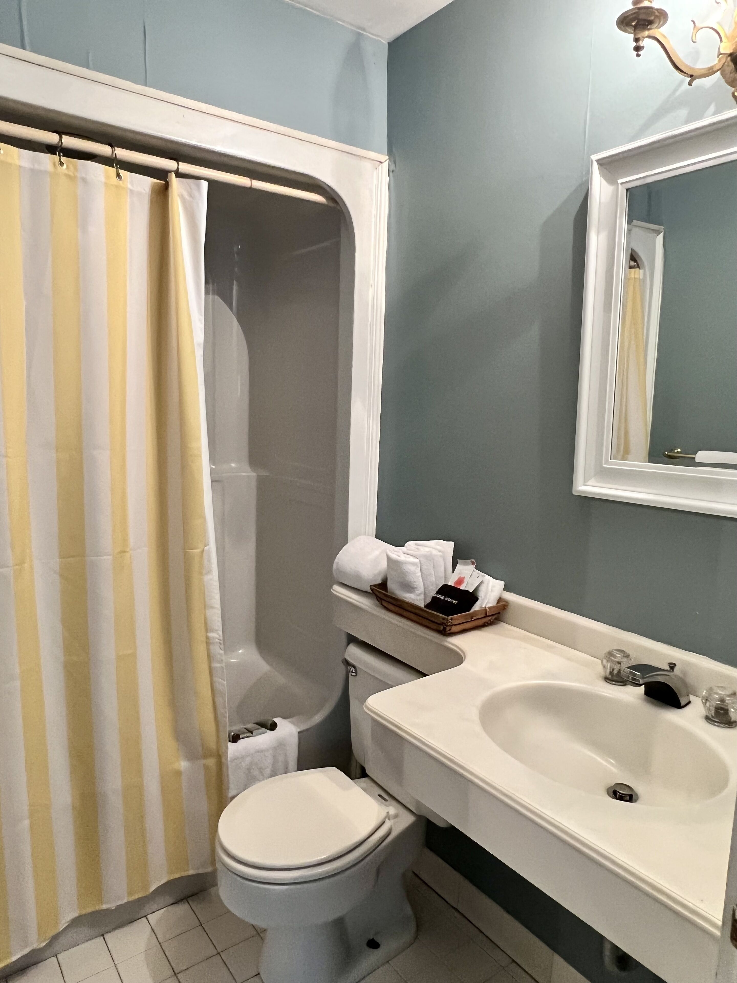 A bathroom with a shower, toilet, and sink.