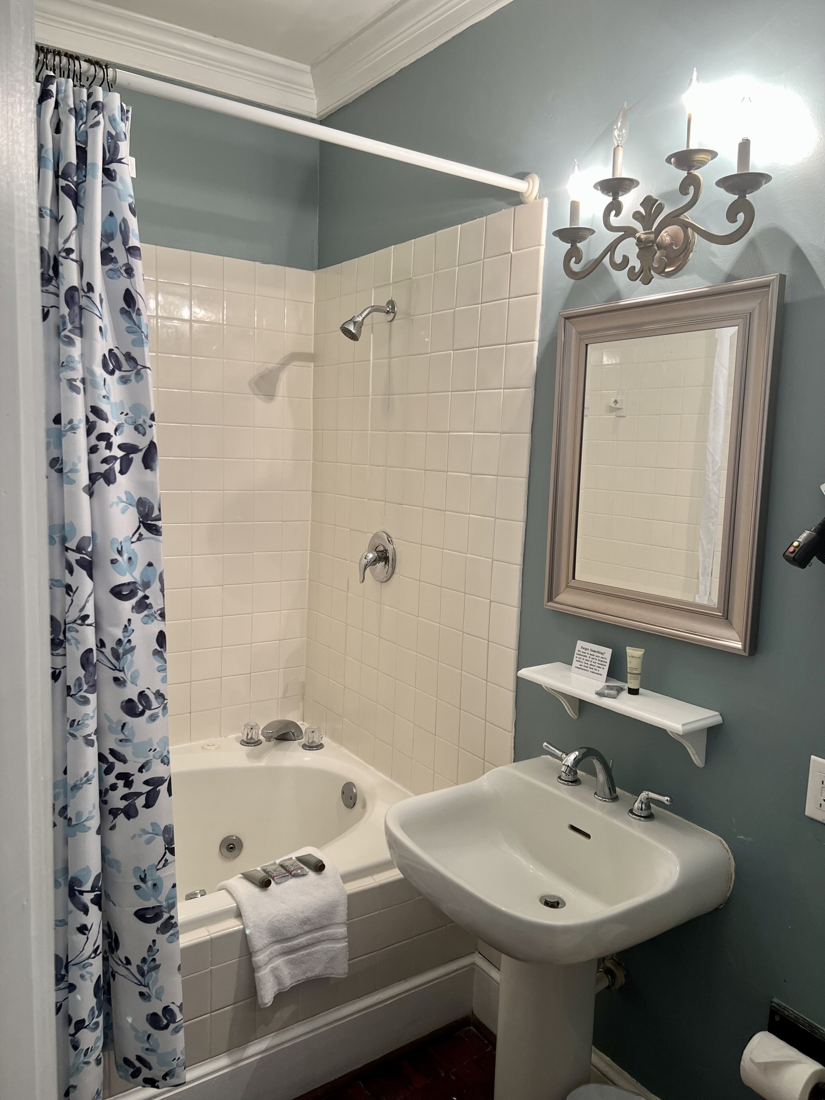 Une salle de bain avec une baignoire, un lavabo, une douche et un miroir.