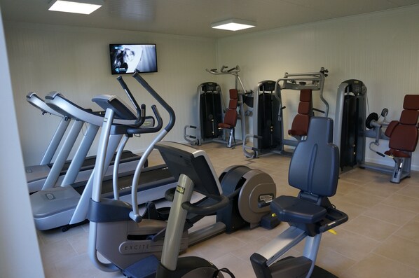 Et fitnesscenter med løbebånd, crosstrainere og styrkemaskiner.