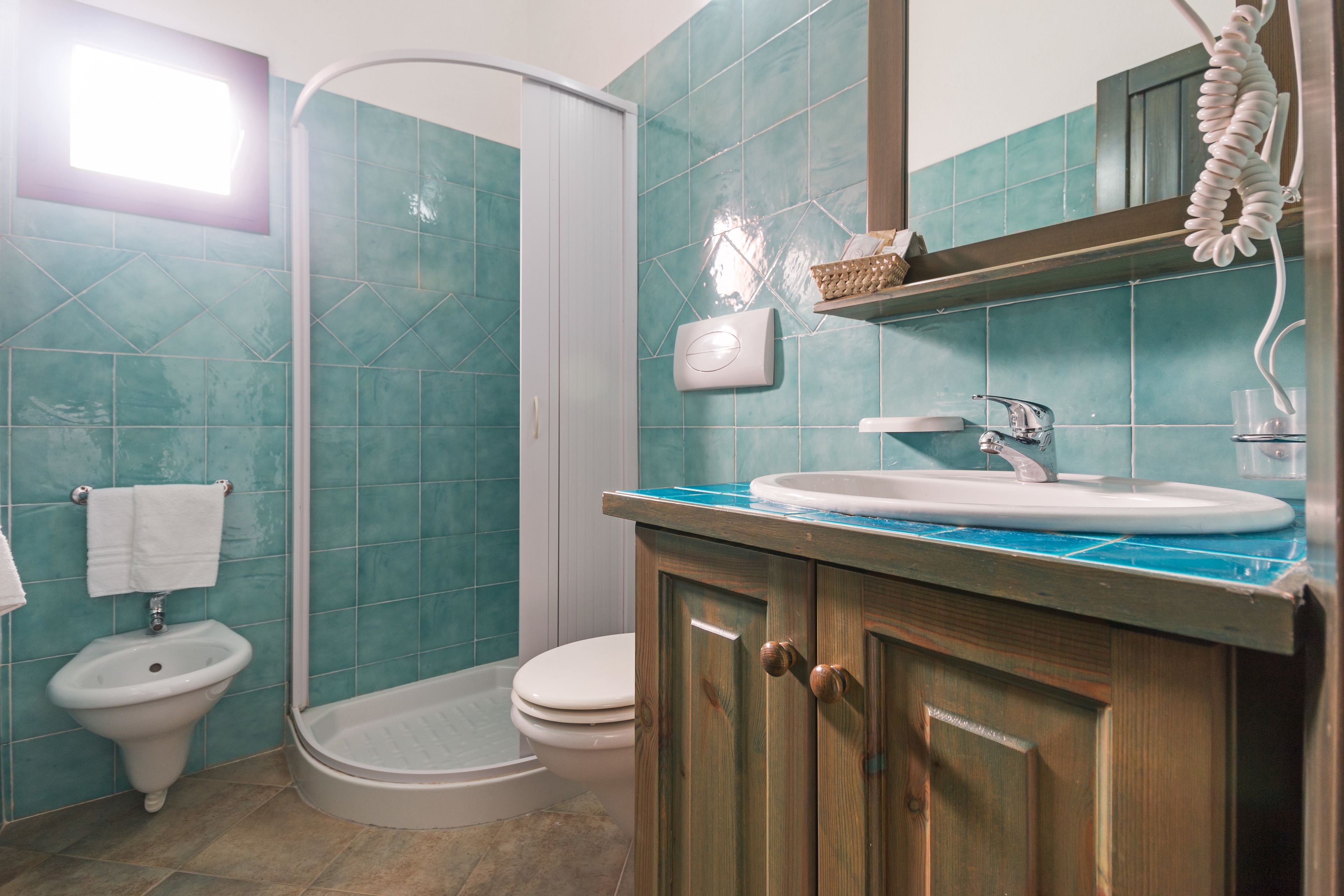 Une salle de bain équipée d’une douche, de toilettes, d’un lavabo et d’un porte-serviettes.