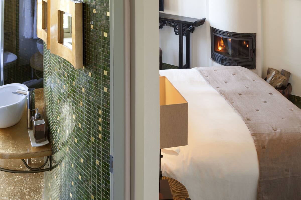 Un baño con pared de mosaicos verdes, un lavabo blanco y un inodoro.